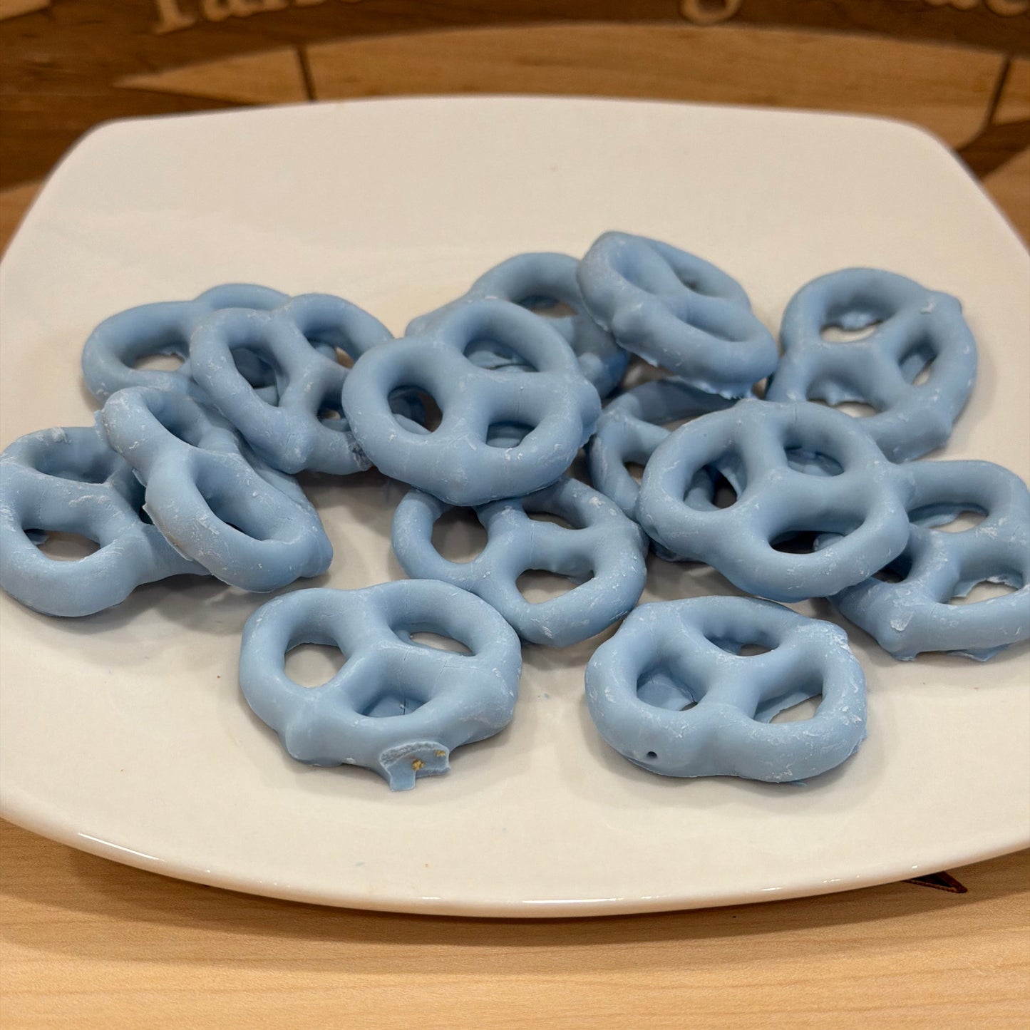 Blue pretzels on a white plate with a wooden background