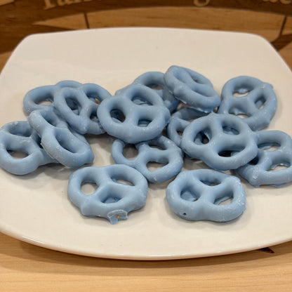 Blue pretzels on a white plate with a wooden background