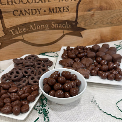 Chocolate treats in white bowls and trays. 