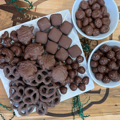 Assortment of chocolates served in white trays and bowls. 