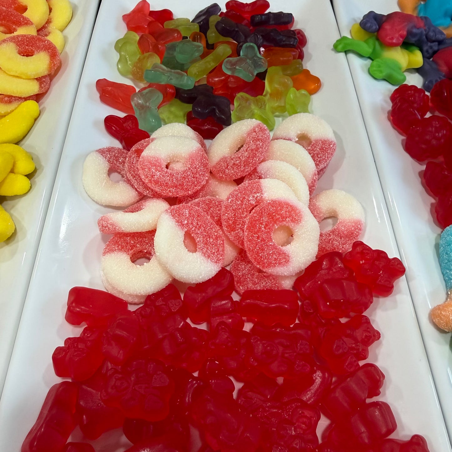 Assorted colorful gummy candies on a white tray