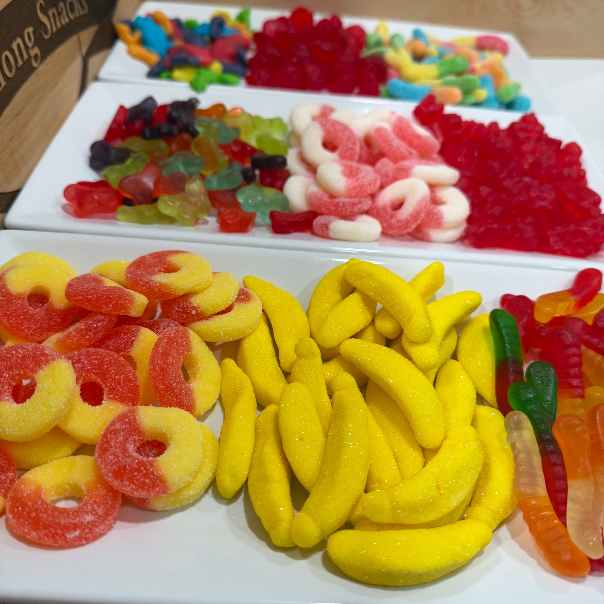 Assorted colorful gummy candies on a white tray.